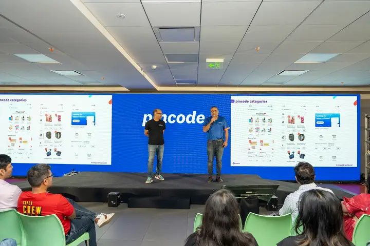 Presenters on stage in front of a Pincode LED screen at a launch event
