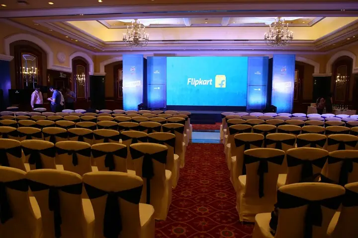 Flipkart event ballroom with an LED screen and chandeliers, chairs set theatre-style