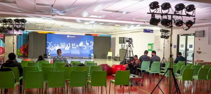 Event venue with a lighting truss, camera rig and PhonePe LED screen