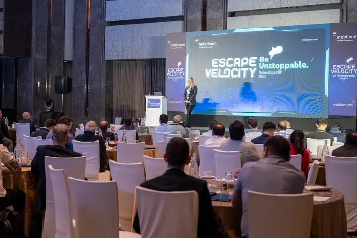 Corporate conference with banquet seating and an “Escape Velocity” stage backdrop
