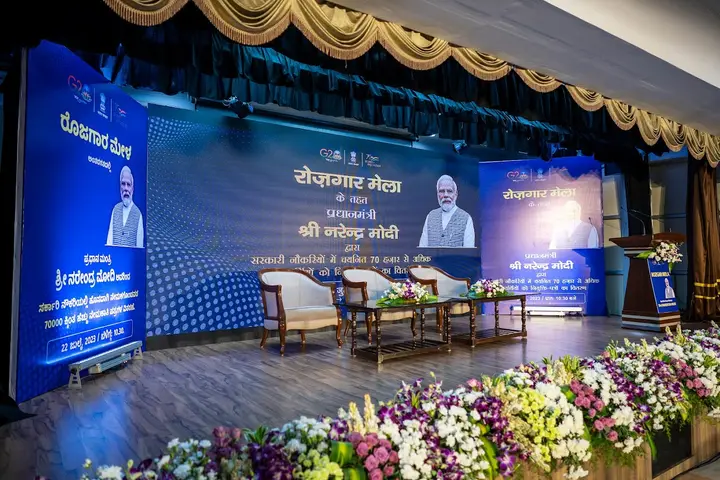 Rozgar Mela stage dressed with flowers and LED screens